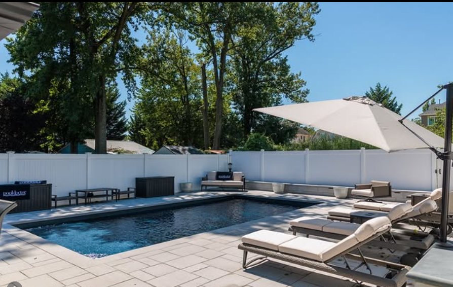 Pool patio with lounge furniture and umbrella